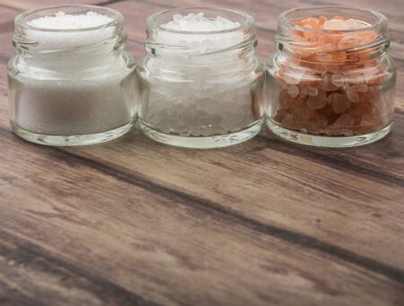 Table salt, sea salt and himalayan salt in mason jar over wooden backgroundの写真素材