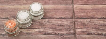 Table salt, sea salt and himalayan salt in mason jar over wooden backgroundの写真素材