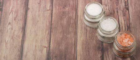 Table salt, sea salt and himalayan salt in mason jar over wooden backgroundの写真素材
