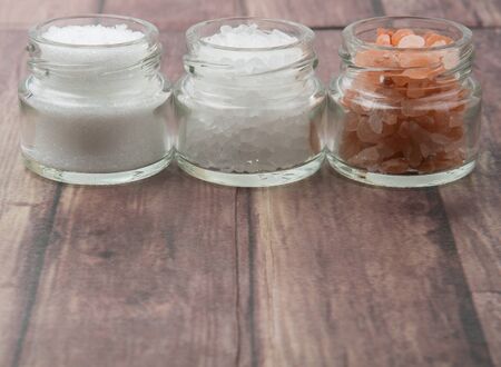 Table salt, sea salt and himalayan salt in mason jar over wooden backgroundの写真素材