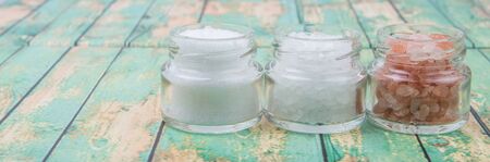 Table salt, sea salt and himalayan salt in mason jar over wooden backgroundの写真素材