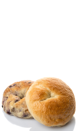 Plain bagel and blueberry bagel over white backgroundの写真素材