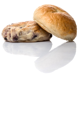 Plain bagel and blueberry bagel over white backgroundの写真素材