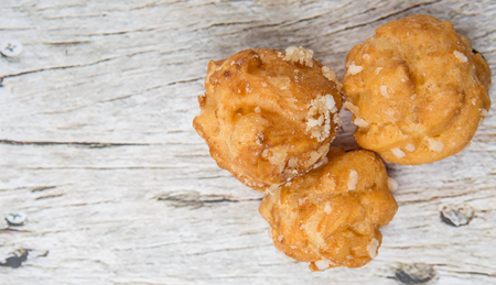 Choux pastry sprinkled with sugar over wooden background