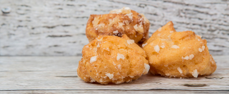 Choux pastry sprinkled with sugar over wooden backgroundの写真素材