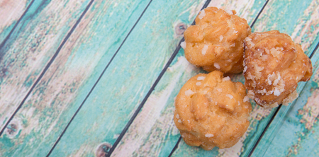 Choux pastry sprinkled with sugar over wooden background