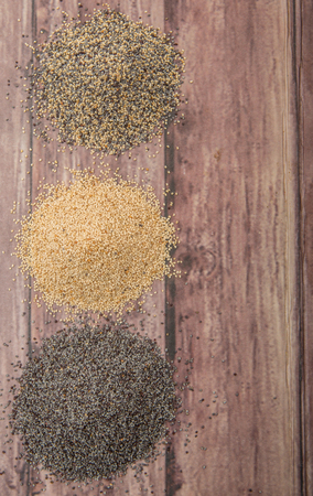 White poppy seed, black poppy seed and mix poppy seed over wooden backgroundの写真素材