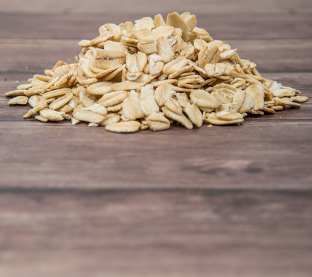 Raw oatmeal over wooden backgroundの写真素材