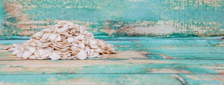 Raw oat cereal in a white bowl over white backgroundの写真素材