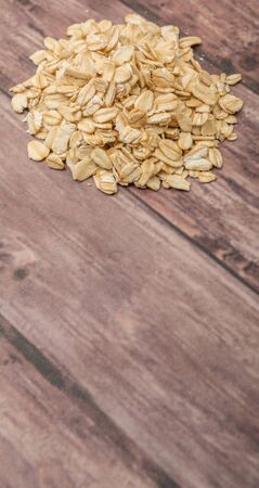 Raw oat cereal in a white bowl over white backgroundの写真素材