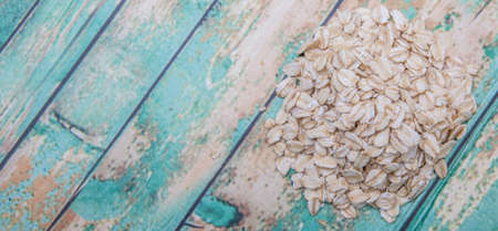 Raw oatmeal over wooden background