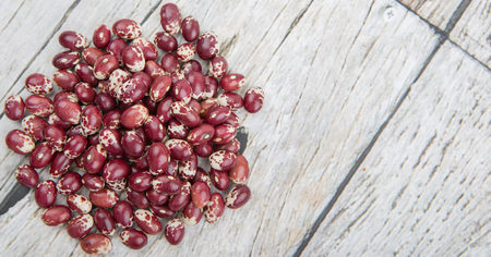 Pinto beans or speckled beans over wooden background