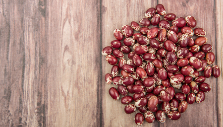 Pinto beans or speckled beans over wooden background