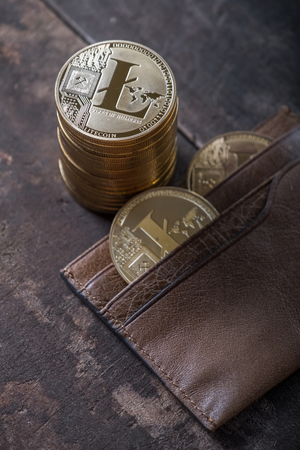 Litecoin with leather wallet on wooden table topの写真素材