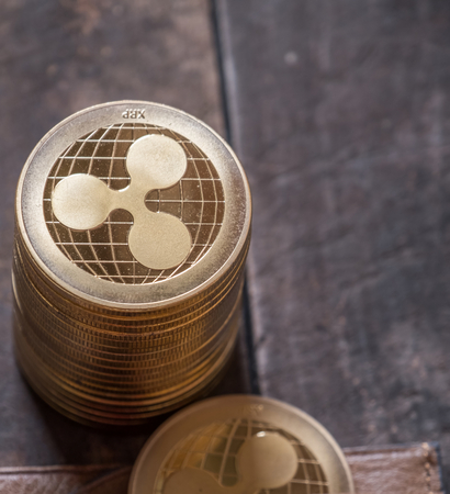 Ripple coin with lether wallet on wooden table top