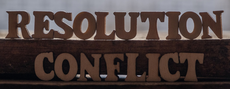 'RESOLUTION' and 'CONFLICT' text on wooden background.の写真素材