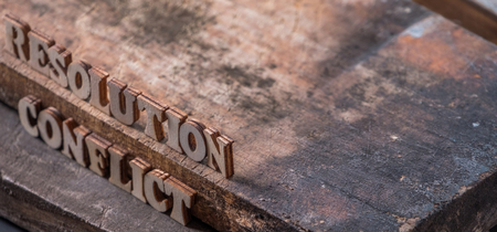 'RESOLUTION' and 'CONFLICT' text on wooden background.の写真素材