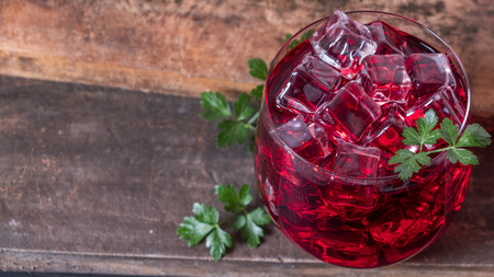 Cold pomegranate juice in s glass with ice.
