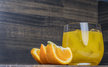 Cold fresh orange juice and fruits on wooden table.の写真素材