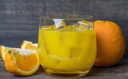 Cold fresh orange juice and fruits on wooden table.の写真素材
