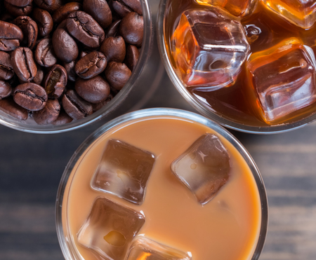 Black iced coffee, cold latte, and beans over wooden backgroundの写真素材