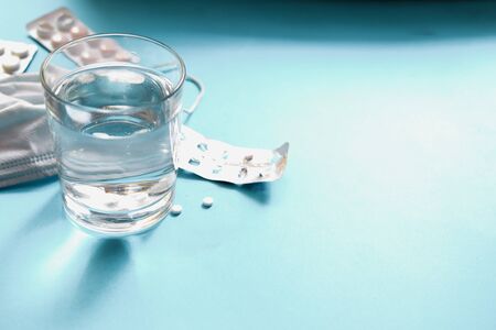 Coronavirus prophylaxis with surgical masks and gloves. Medical mask, pills, drugs, water in a...