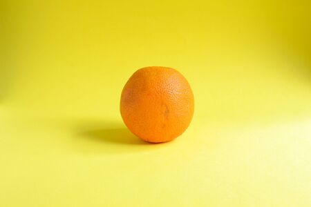 Minimal food concept. Orange fruit on a bright yellow background. Free space for text. Top view....