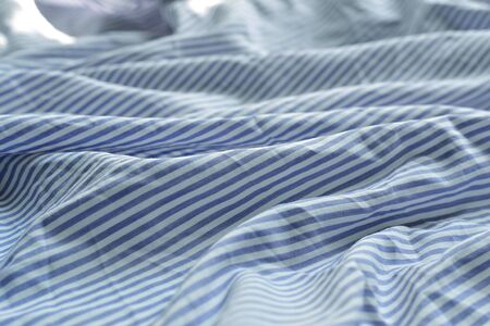 Striped fabric. Cotton, bedding, blue and white stripes on the fabric. Texture. Background.