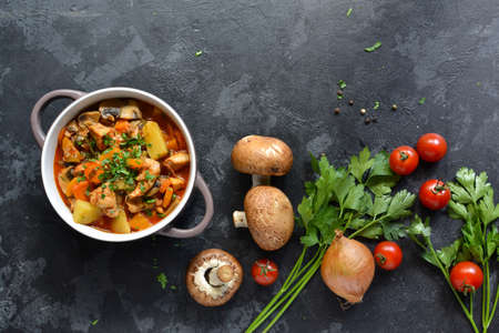 Stew with chicken, potatoes, onions, mushrooms, tomatoes and carrots, and parsley. Vegetable stew