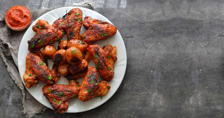 Fried chicken wings in soy-honey sauce. Top view. Free space for text. Dark background.の写真素材