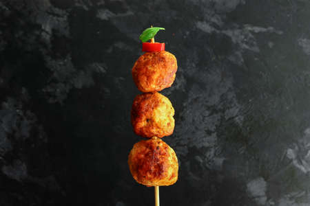 Chicken meatballs with basil Dark background. Copyspace. Meatballs on a wooden skewer. Isolatedの写真素材