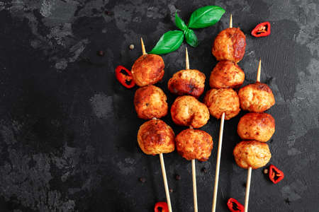 Chicken meatballs with basil Dark background. Copyspace. Meatballs on a wooden skewerの写真素材