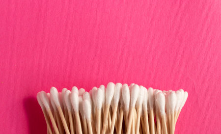 Ear cleaning sticks on a pink isolated background. Copy space. Personal hygiene. Minimal concept.の写真素材