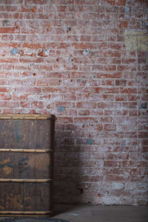 Old wood suitcase on red brick wall
