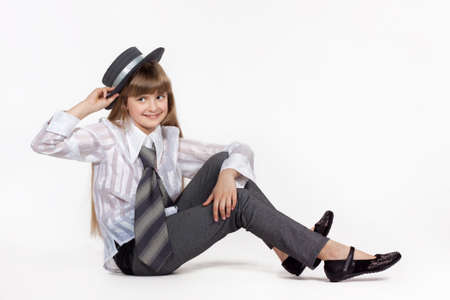 Seated girl in retro hat on a white backgroundの写真素材