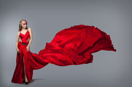 blonde in windy red  dress. Beautiful girl with creative make-upの写真素材