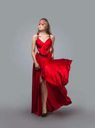 blonde in windy red and white dress. Beautiful girl with creative make-upの写真素材