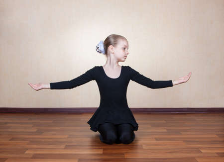 little girl gymnast sitting on the floorの写真素材
