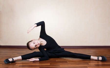 little girl gymnast sitting on the floorの写真素材