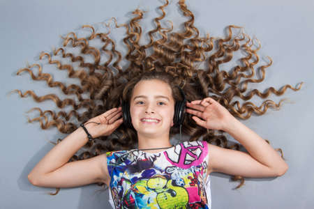 girl with beautiful hair lies in the headphonesの写真素材