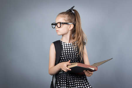 little smart girl reading a book Girl with glasses reading a bookの写真素材