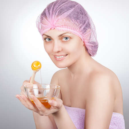 Spa woman. Beautiful adult woman cares for your skin. The mask of honey for skinの写真素材