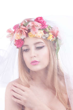 Portrait of a young beautiful girl. bride in veil. Girl with a veil on his face and flowers in her hairの写真素材