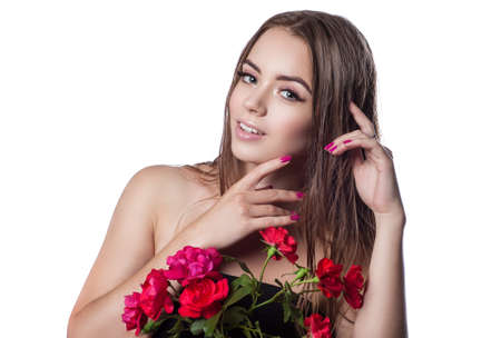 Portrait of a beautiful girl with wet hair. Happy girl on a white background. Keep in front of red rosesの写真素材