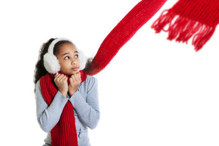 A beautiful dark-skinned girl in a red scarf. Cold. Girl frozeの写真素材