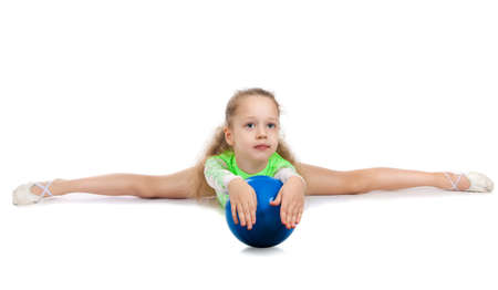 Gymnast cute little girl sitting on the floor. The child in the gymnastics suit doing the splitsの写真素材