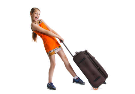 cute girl ready for summer vacation. Joyful girl with luggage bag about to travel. she carries a big heavy bag. Isolation on a white backgroundの写真素材