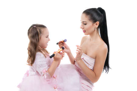 Happy loving family. Mother and daughter are doing your makeup and having fun. Mother and daughter laughing painting each otherの写真素材