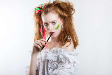 beauty portrait of a young red-haired girl with creative hairstyle and makeup