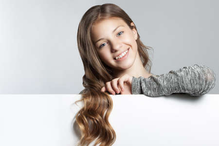 Pretty happy girl close-up with empty blank. Positive human emotions. Space for text. Stock photoの写真素材